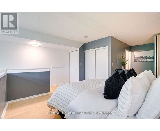 A bedroom with a bed, pillows and a nightstand.