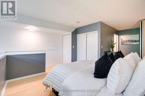 A bedroom with a bed, pillows and a nightstand.