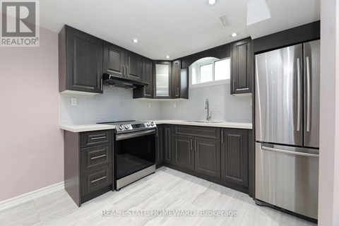 A modern kitchen with dark wood cabinets and stainless steel appliances.