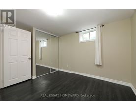 A bedroom with a white door and a mirror on the wall.