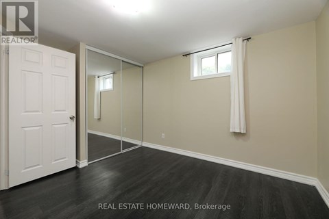 A bedroom with a white door and a mirror on the wall.