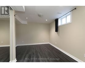 A spacious room with a window and a sign that says REAL ESTATE HOMEWARD.