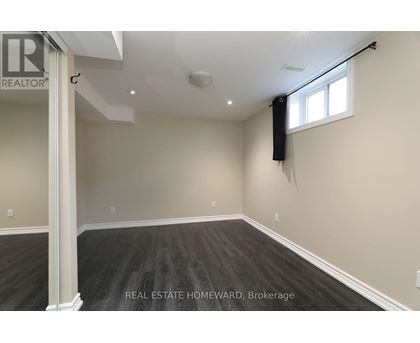 A spacious room with a window and a sign that says REAL ESTATE HOMEWARD.