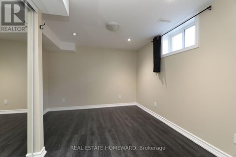 A spacious room with a window and a sign that says REAL ESTATE HOMEWARD.