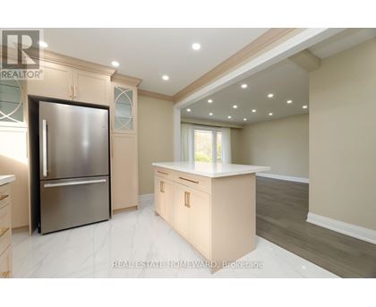 A modern kitchen with a stainless steel refrigerator and wooden cabinets.