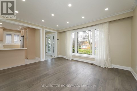 A spacious living room with a sliding glass door leading to a backyard.