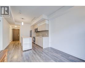 A kitchen with a refrigerator, microwave, and oven in a white cabinetry.