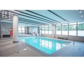 A large indoor swimming pool with a glass wall on one side.
