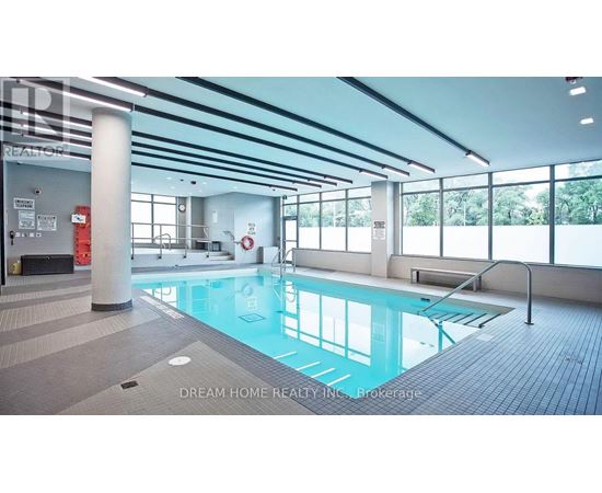 A large indoor swimming pool with a glass wall on one side.