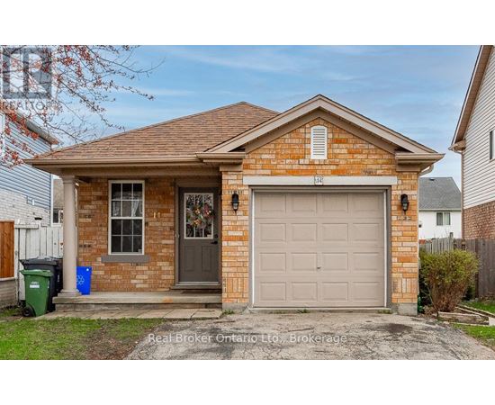 A small brick house with a grey garage door is for sale.