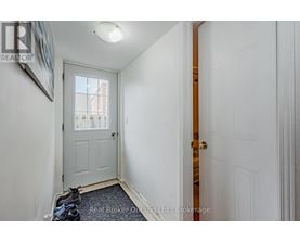 A hallway with a white door and a window.