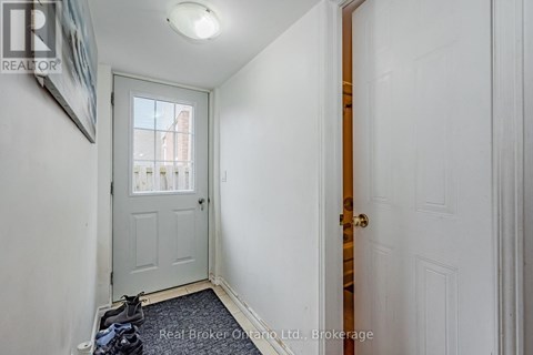 A hallway with a white door and a window.