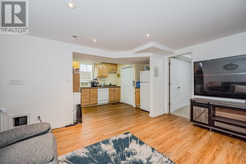 A living room with a grey couch and a wooden floor.
