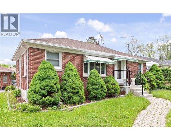 A red brick house with a green lawn in front.