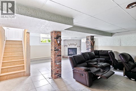 A living room with a couch, chair, and fireplace.