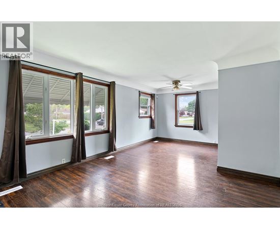 A room with wooden floors and a ceiling fan.