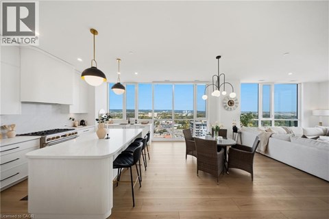 A modern kitchen with a large island and a dining area with a view.