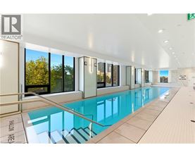 A swimming pool inside a building with a glass wall.