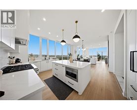 A modern kitchen with white cabinets and a black stove top.