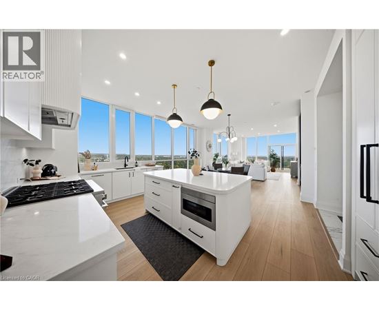 A modern kitchen with white cabinets and a black stove top.