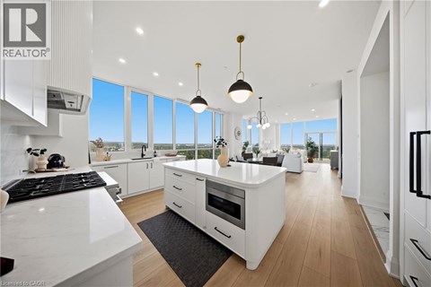 A modern kitchen with white cabinets and a black stove top.