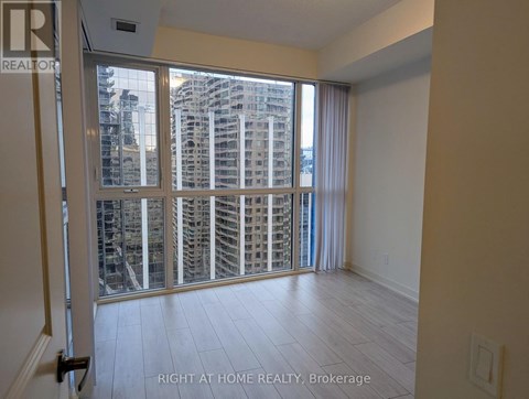 A room with a view of a cityscape through a large window.