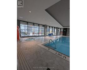A swimming pool inside a building with a sign that says "1.07.M".
