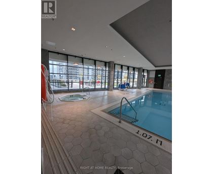 A swimming pool inside a building with a sign that says "1.07.M".