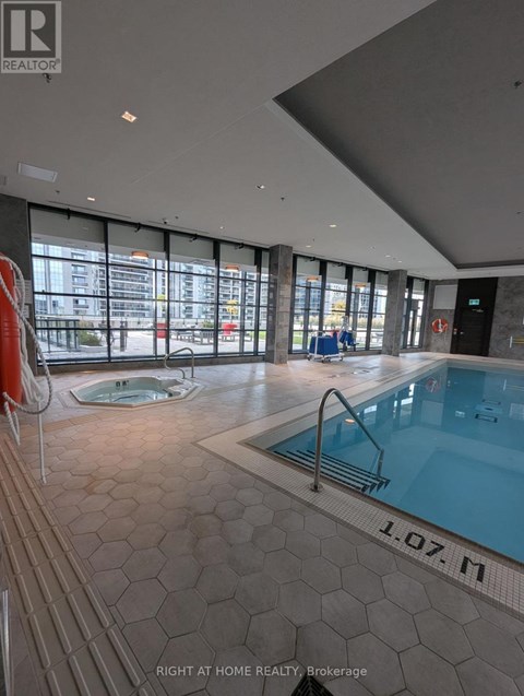A swimming pool inside a building with a sign that says "1.07.M".
