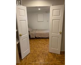 A bedroom with a bed and a wooden floor.
