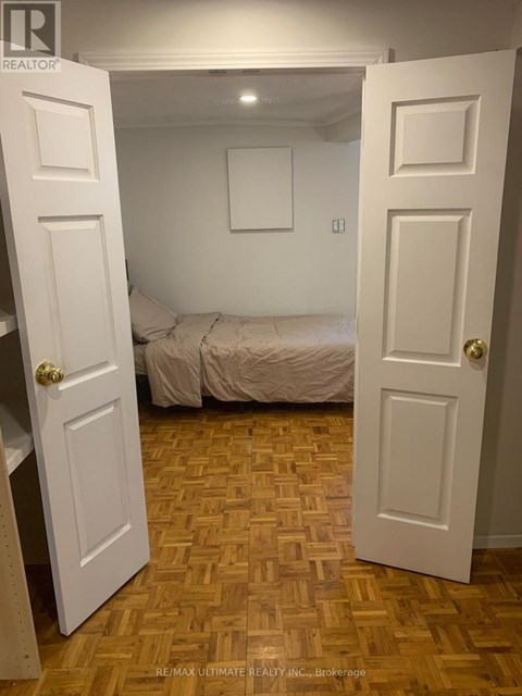 A bedroom with a bed and a wooden floor.