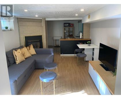 A living room with a grey couch and a fireplace.