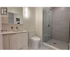 A bathroom with a toilet, sink, and shower.