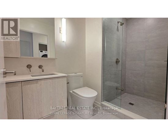 A bathroom with a toilet, sink, and shower.