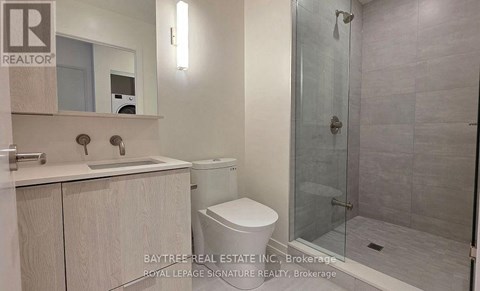 A bathroom with a toilet, sink, and shower.
