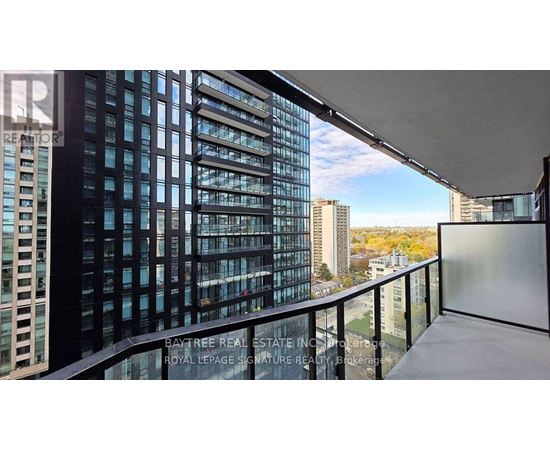A balcony with a view of a cityscape and a building with the words "Bay Tree Real Estate" on it.