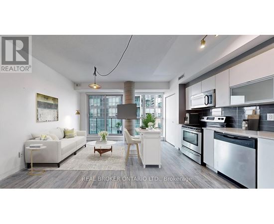 A modern kitchen with stainless steel appliances and a dining area with a white sofa and chairs.