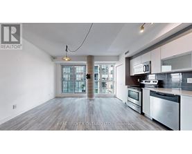 A spacious kitchen with stainless steel appliances and a view of the city.