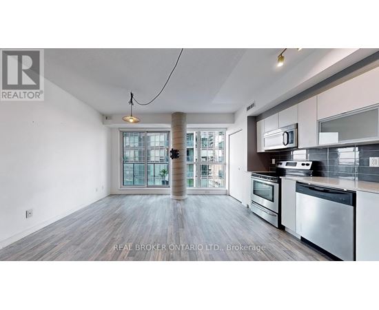 A spacious kitchen with stainless steel appliances and a view of the city.