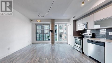 A spacious kitchen with stainless steel appliances and a view of the city.