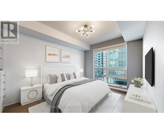 A bedroom with a large bed, a lamp, and a window overlooking a cityscape.
