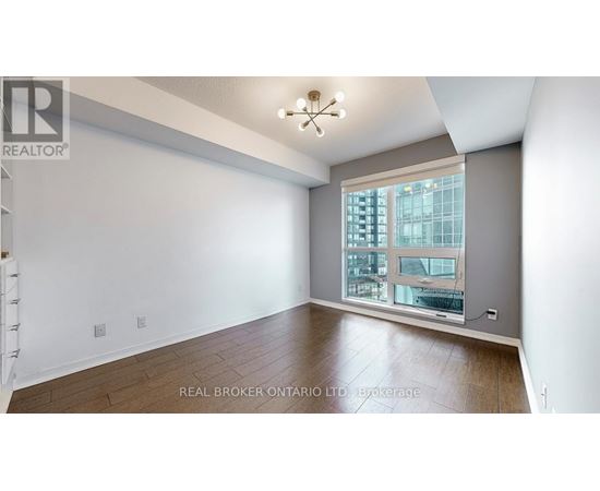 A spacious room with a large window overlooking a cityscape.