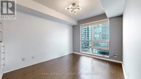 A spacious room with a large window overlooking a cityscape.