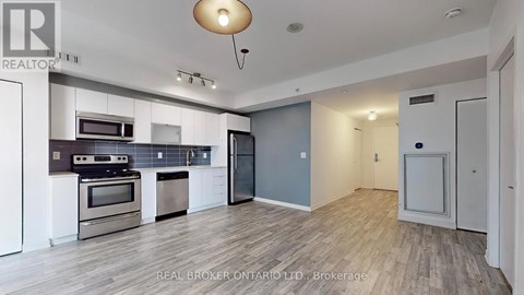 A spacious kitchen with a stainless steel refrigerator and oven.