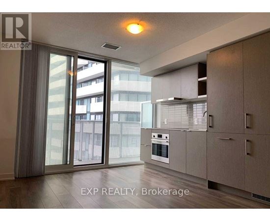 A modern kitchen with a sliding glass door leading to a balcony.