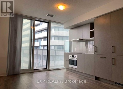 A modern kitchen with a sliding glass door leading to a balcony.