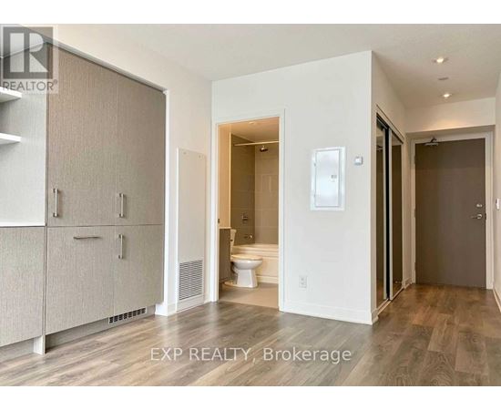 A bathroom with a toilet, sink, and a cabinet.
