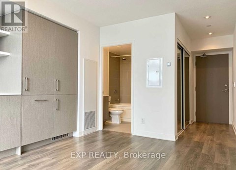 A bathroom with a toilet, sink, and a cabinet.