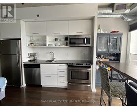 A kitchen with a refrigerator, oven, and sink.
