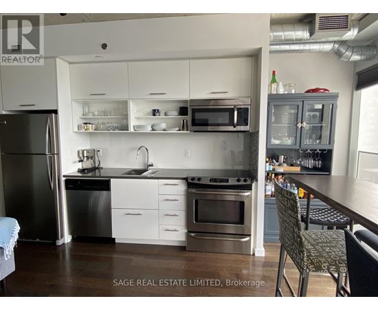 A kitchen with a refrigerator, oven, and sink.